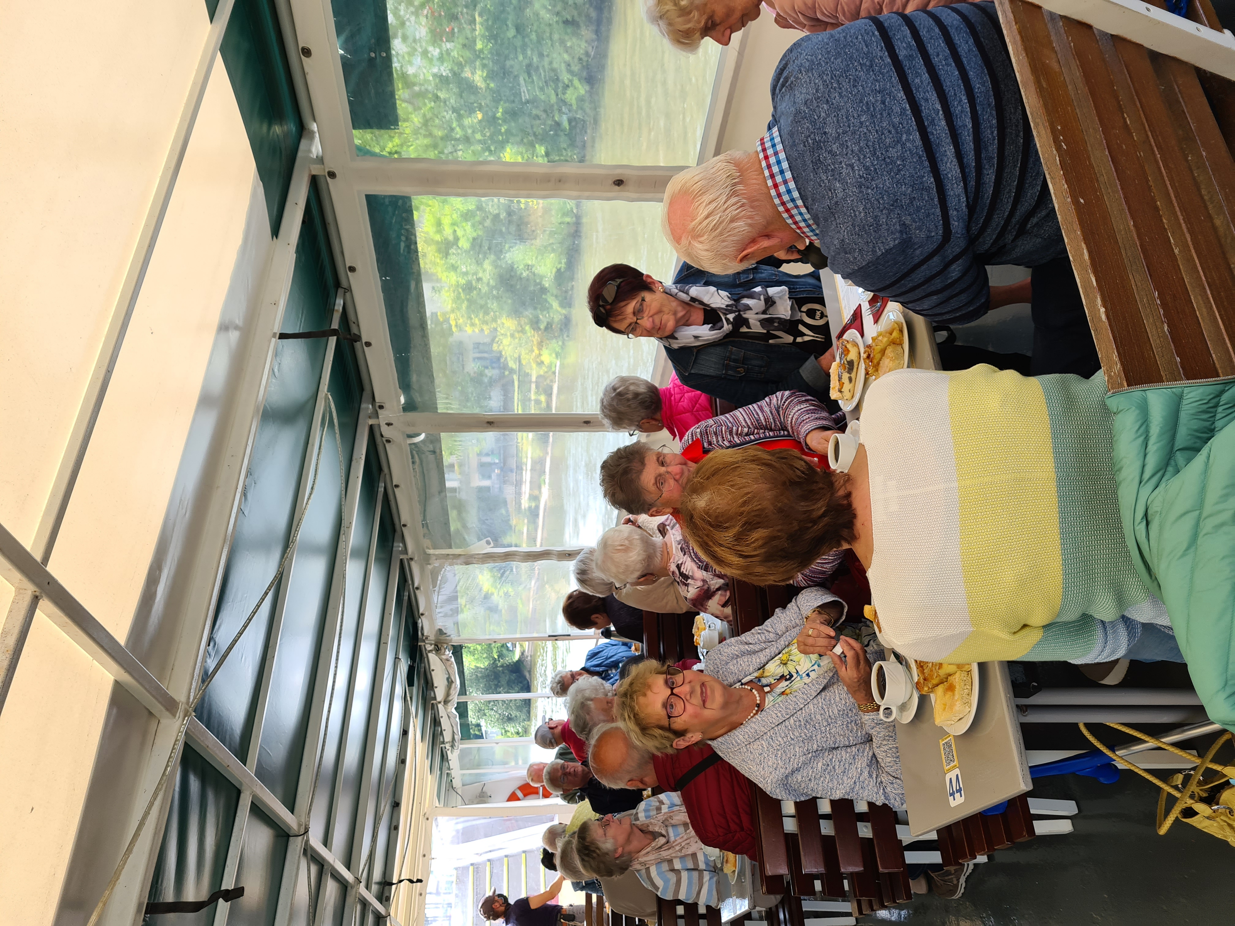 Die Senioren sitzen an Tischen und trinken Kaffee